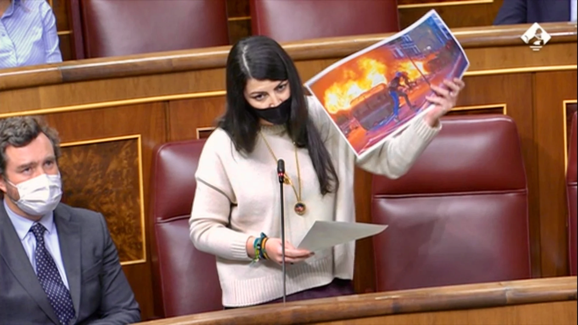 Macarena Olona durante la sesión de control al Gobierno muestra una fotografía de la "kale borroka" catalana