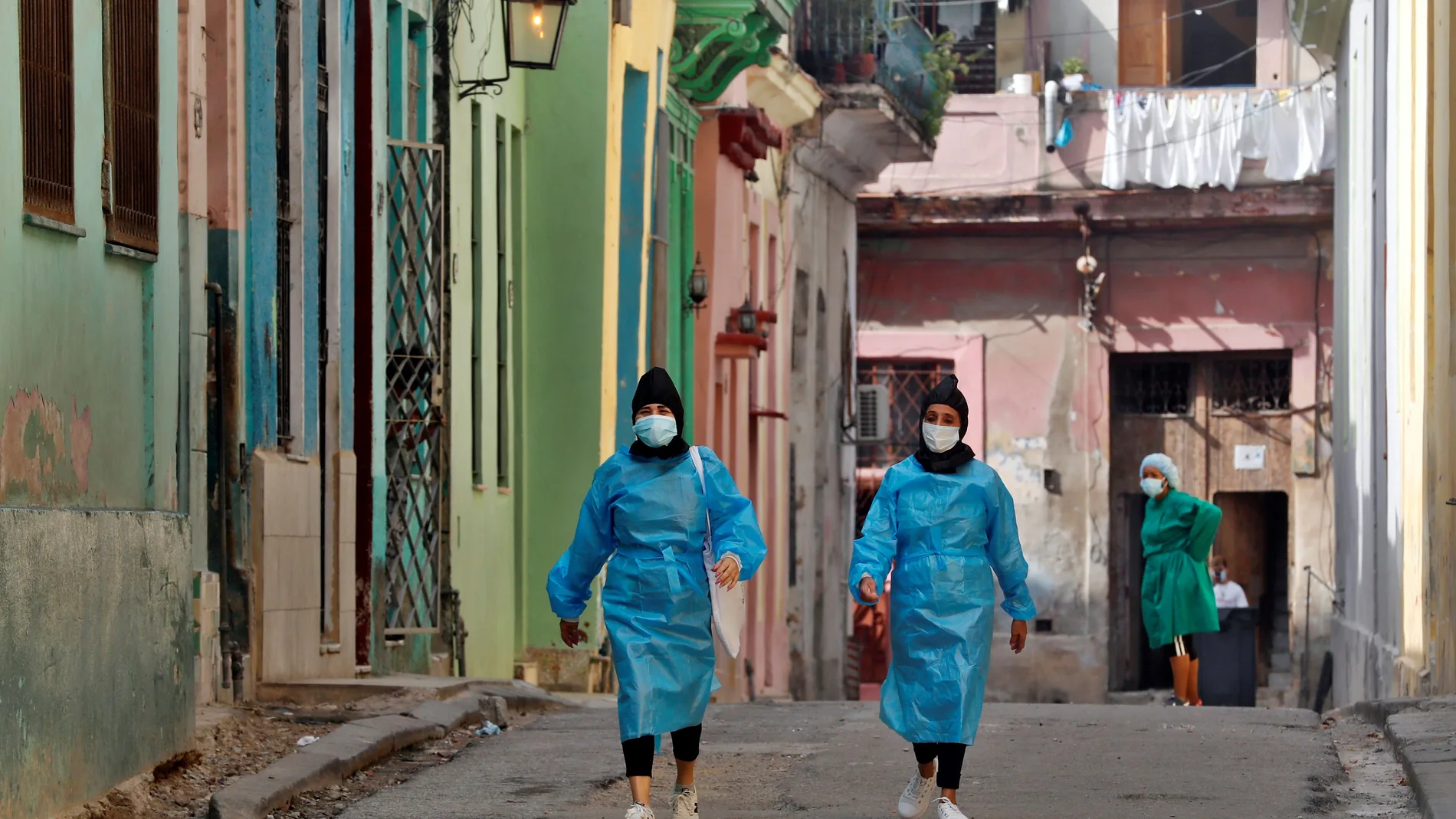 Trabajadoras de la salud recorren una calle cerrada por la pandemia, en La Habana (Cuba)
