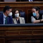 El presidente del Gobierno, Pedro Sánchez (i), conversa con sus vicepresidentes Carmen Calvo, y Pablo Iglesias (d), en el último Pleno del Congreso