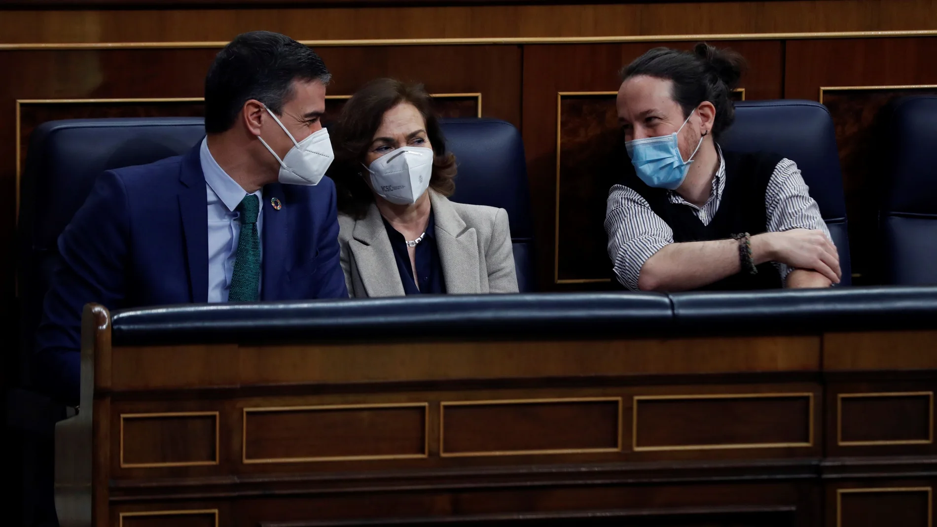 El presidente del Gobierno, Pedro Sánchez (i), conversa con sus vicepresidentes Carmen Calvo, y Pablo Iglesias (d), en el último Pleno del Congreso