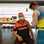 Un sanitario vacuna a un trabajador de protección civil en el punto de vacunación contra el Covid-19 puesto en marcha en el Estadio Wanda Metropolitano de Madrid