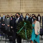 El presidente de la Junta de Andalucía, Juanma Moreno, y la presidenta del Parlamento, Marta Bosquet, realizando una ofrenda floral por los fallecidos en la pandemia en el acto institucional por el 28F