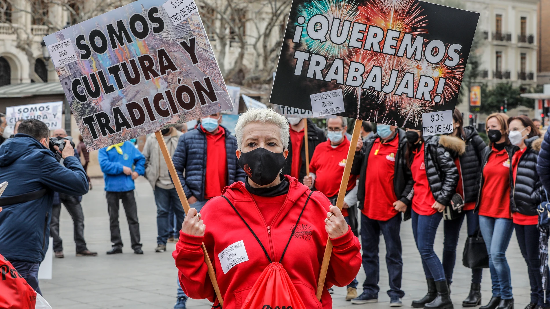 Una mujer sostiene una pancarta donde se lee "¡Queremos trabajar!" durante una protesta en la Plaza del Ayuntamiento, en Valencia
