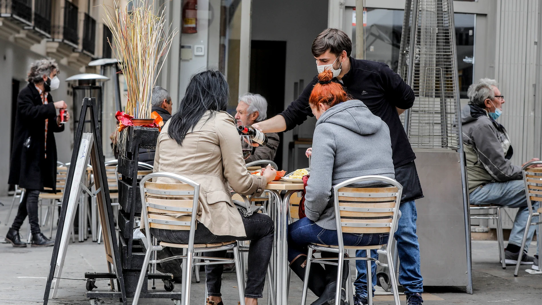 Un camarero atiende a dos clientas en una terraza de Valencia