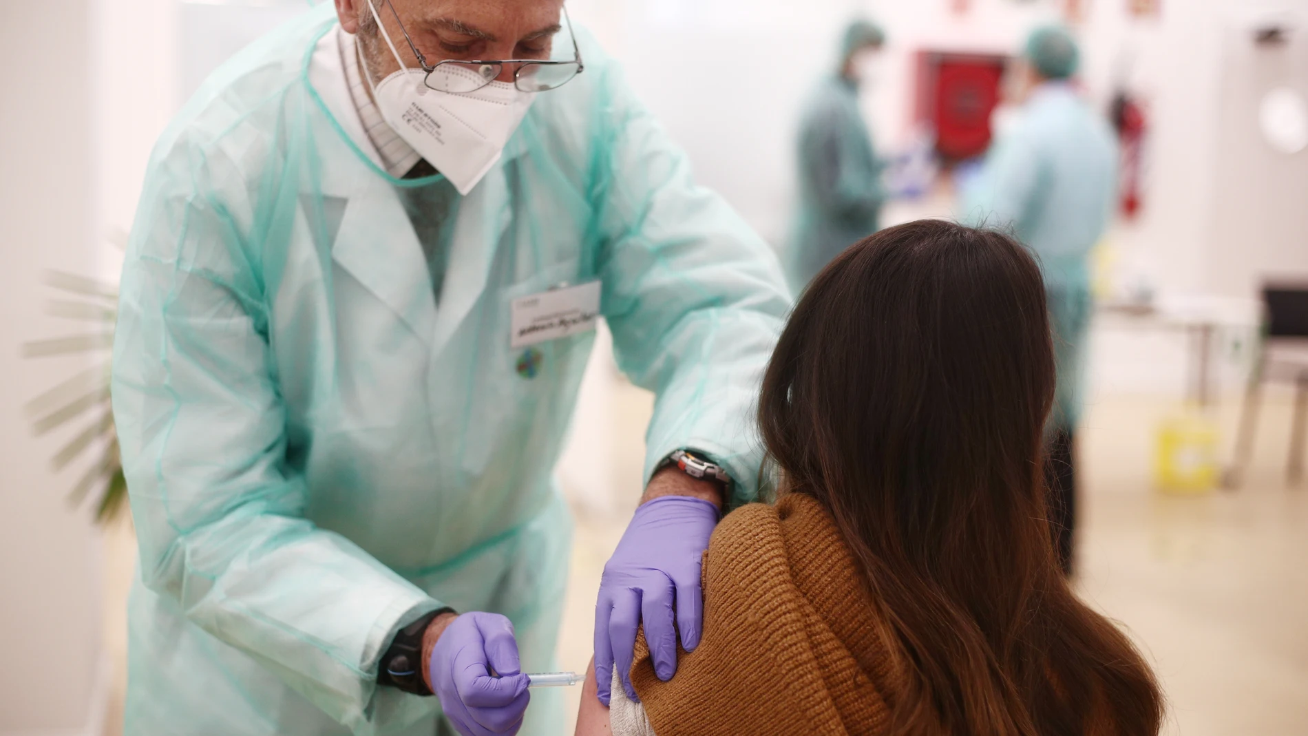 Una profesional farmacéutica recibe la vacuna contra la COVID-19, en la sede del Colegio Oficial de Farmacéuticos de Madrid (COFM), en Madrid