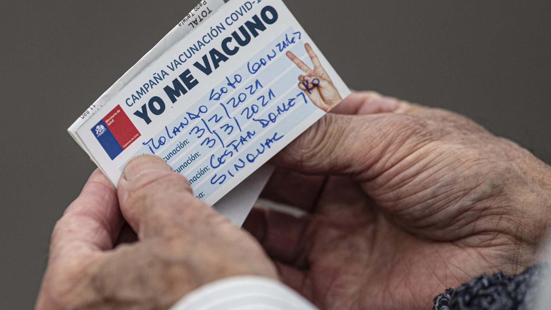 FILE - In this Wednesday, Feb. 3, 2021, file photo, an elderly man looks at his vaccination card after getting a shot of the CoronaVac vaccine for COVID-19 developed by China's biopharmaceutical company Sinovac Biotech, at a clinic in Santiago, Chile. It wasnâ€™t until Sinovac swooped in with 4 million doses in late January that Chile began inoculating its population of 19 million with impressive speed. (AP Photo/Esteban Felix, File)