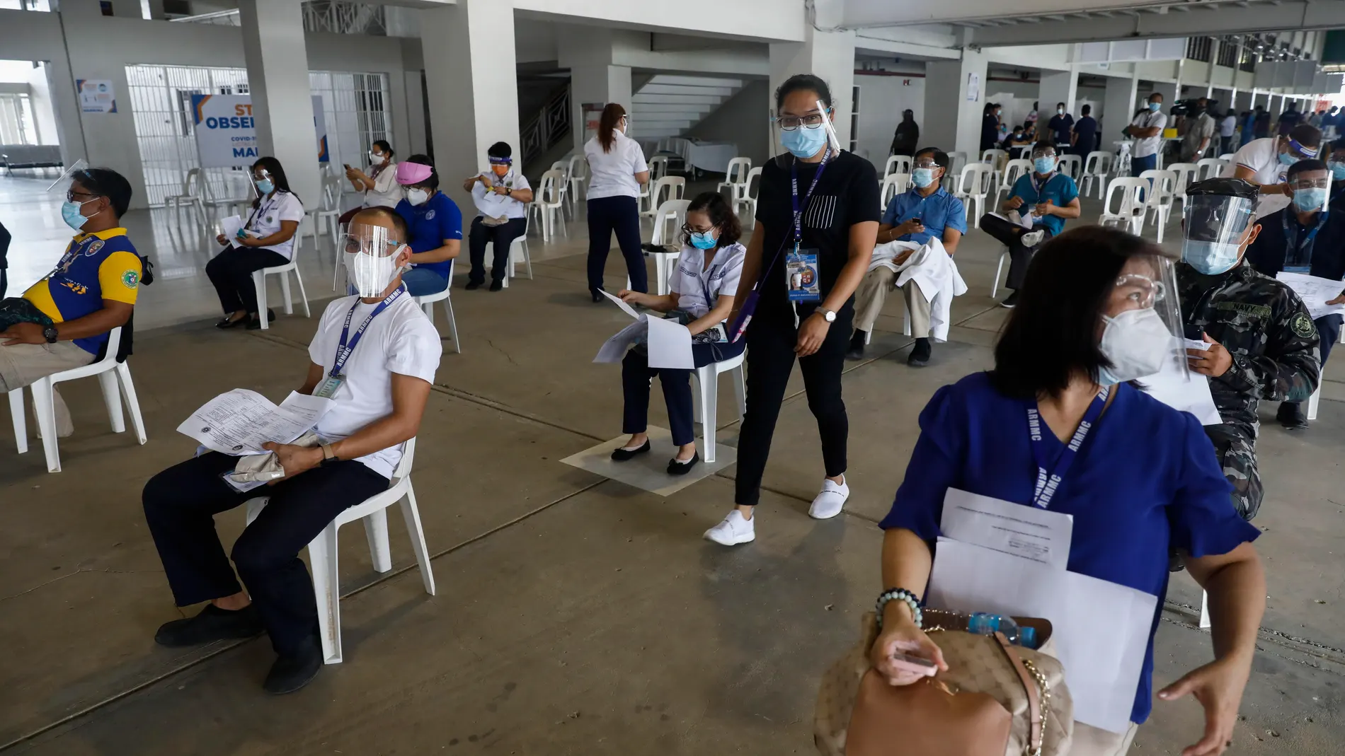 Manila (Philippines), 02/03/2021.- Hospital workers who received their doses of Sinovac COVID-19 vaccine take seats in an observation area used to check for possible side effects, at a sports complex in Marikina City, Metro Manila, Philippines 02 March 2021. The first shipment of Sinovac vaccine from China arrived on 28 February, more than a year after the Philippines announced its first recorded case of the coronavirus in the country. (Filipinas) EFE/EPA/ROLEX DELA PENA
