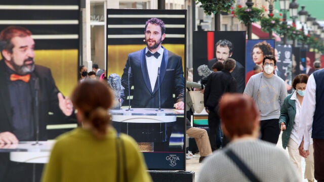 Varias personas pasean por calle Larios, donde ha sido inaugurada una exposición de fotografías de los Premios Goya