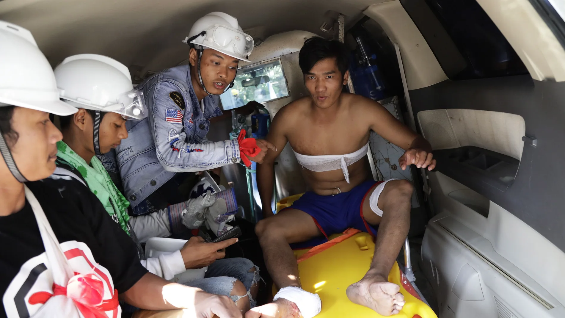 Los médicos atienden a un joven herido hoy durante las protestas en contra de la Junta Militar en Birmania