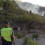 Una agente de la Guardia civil observa un fuego originado en la montaña