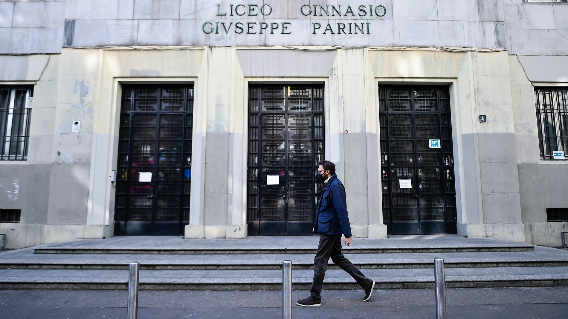 Un hombre pasa junto a un colegio cerrado en Milán