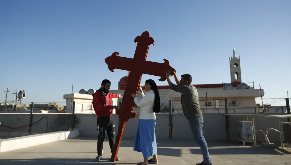 Cristianos iraquíes colocan una cruz en una iglesia en Qaraqosh