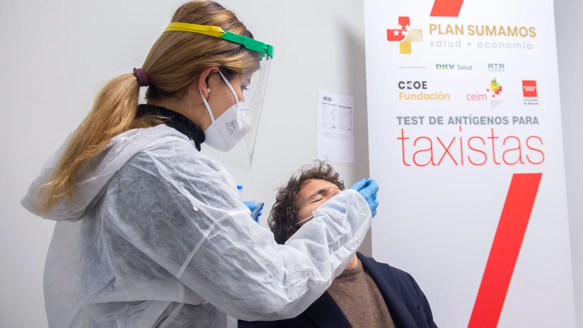 Una trabajadora sanitaria realiza un test de antígenos a un taxista de la Comunidad de Madrid, en Madrid