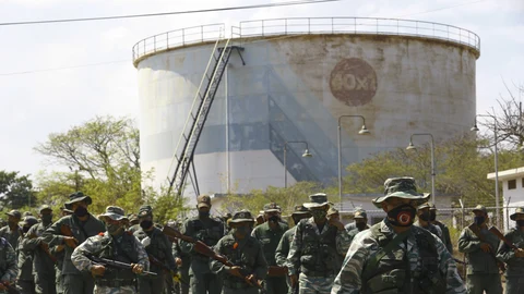 Soldiers patrol near an oil refinery during a military drill to mark the eighth death anniversary of President Hugo Chavez, in Puerto La Cruz, Venezuela, Friday, March 5, 2021. (AP Photo/Juan Carlos Hernandez Soria)
