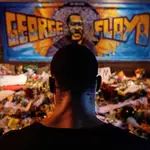 Un hombre negro rinde tributo a George Floyd en uno de los altares esporadicos en Mineápolis