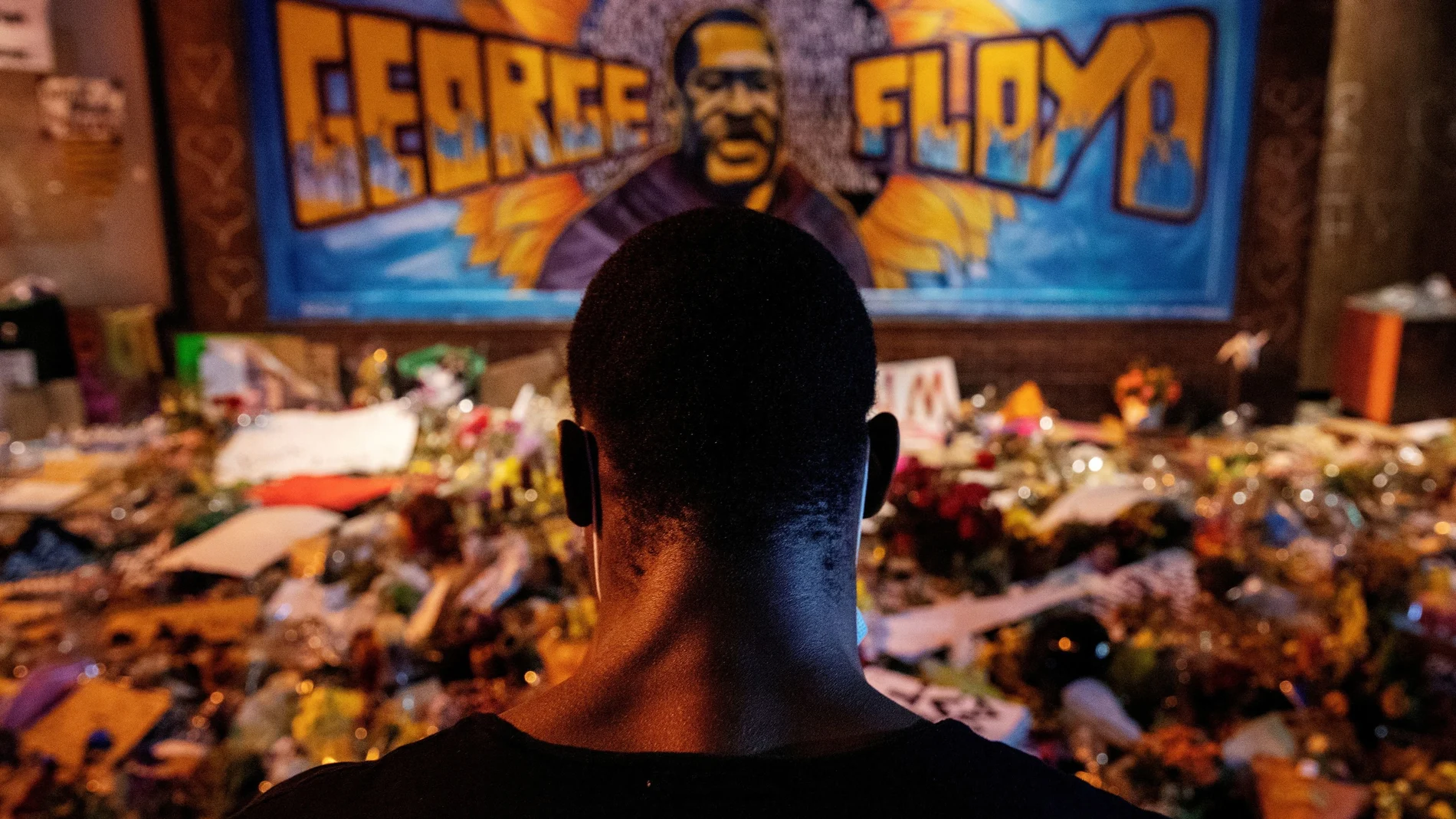 Un hombre negro rinde tributo a George Floyd en uno de los altares esporadicos en Mineápolis