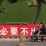 Un hombre con una moto en una calle de Pekín