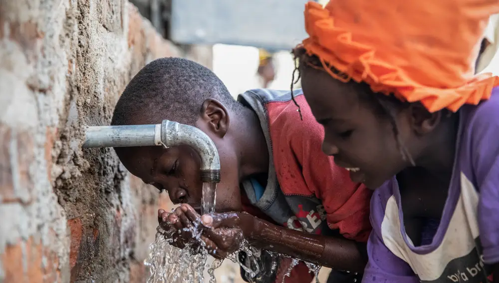 Los niños de la aldea acuden al nuevo pozo de agua potable construido por la ong WATER is LiFE