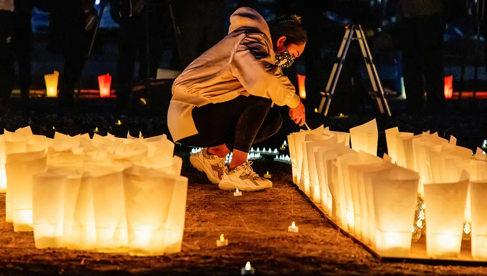 Una mujer enciende una vela en el décimo aniversario del terremoto