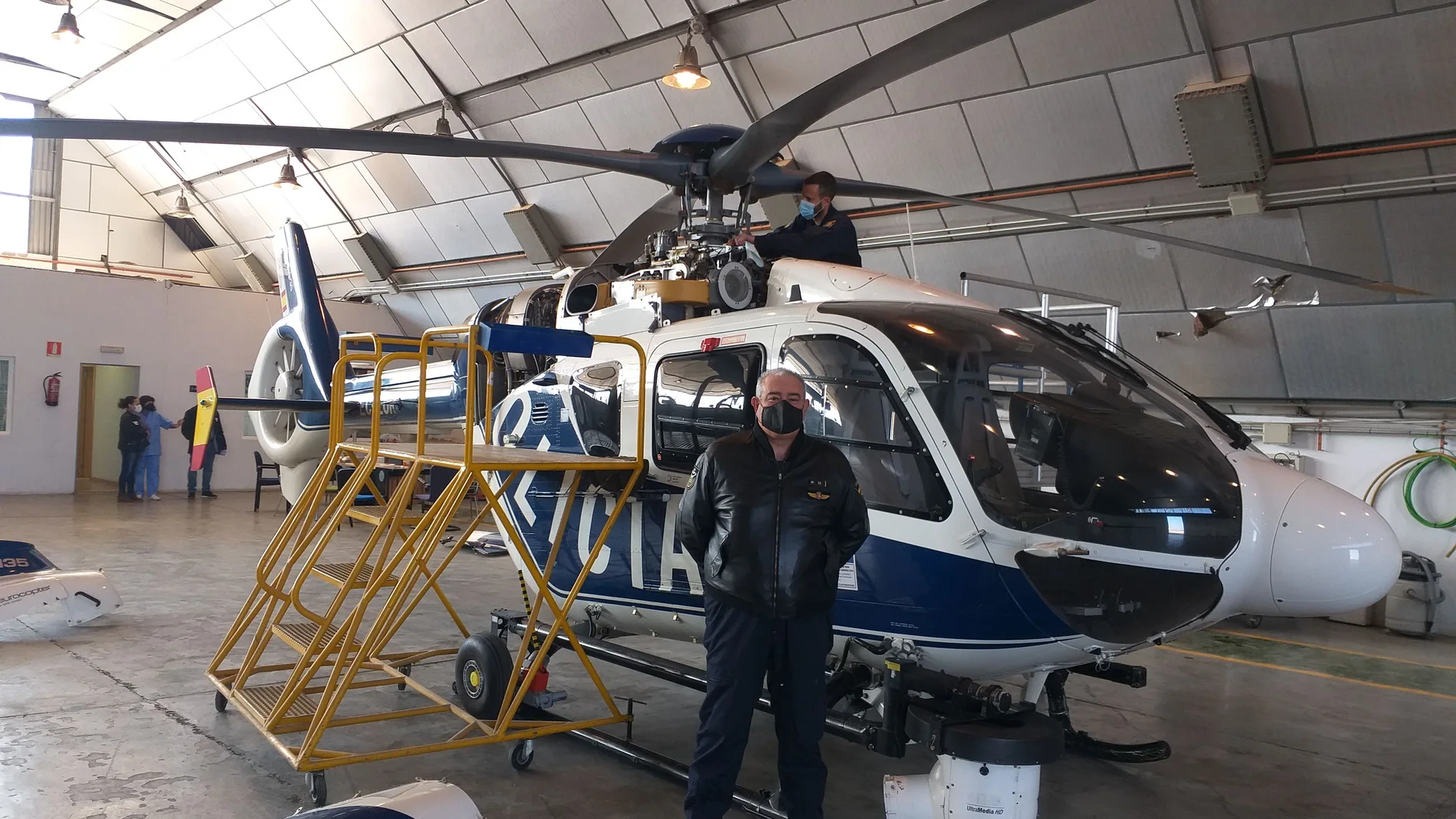 El inspector jefe y comandante de vuelo, Onofre Moncholí, ante el helicóptero que la Policía Nacional tiene destinado en Valencia. Uno de sus hombres revisa que todo esté a punto.
