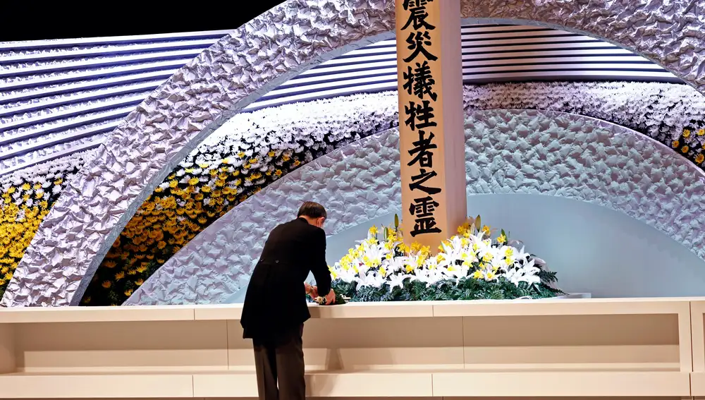 El primer ministro de Japón, Yushihide Suga, pone flores en el altar