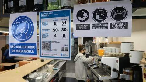 Varios carteles donde se muestra el aforo y el código QR en la puerta de un restaurante en La Coruña (Galicia)