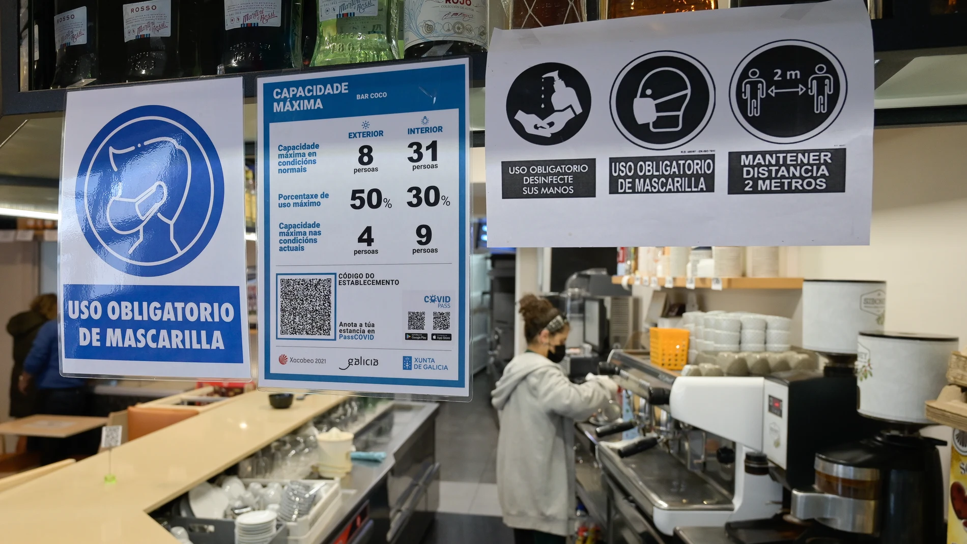 Varios carteles donde se muestra el aforo y el código QR en la puerta de un restaurante en La Coruña (Galicia)