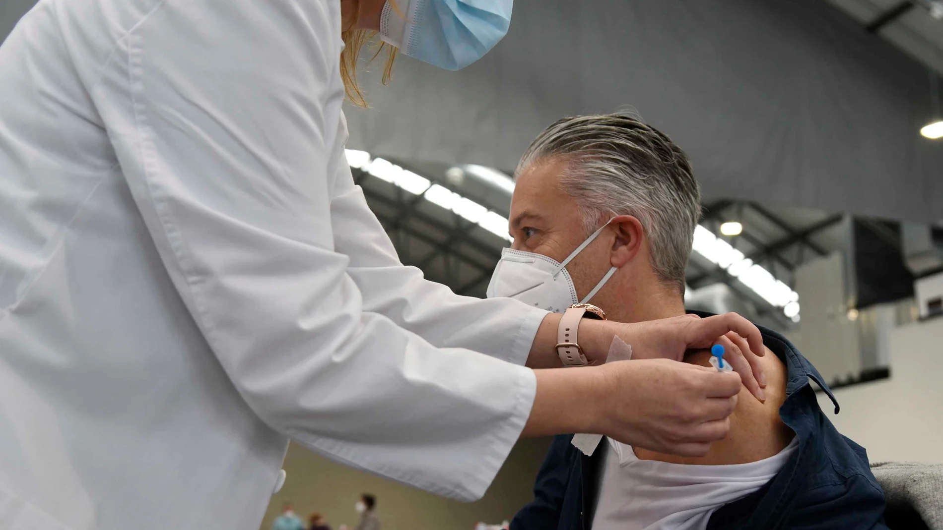 Una sanitaria vacuna a una hombre en el Instituto Ferial de Vigo (Ifevi), en Pontevedra, Galicia (España)