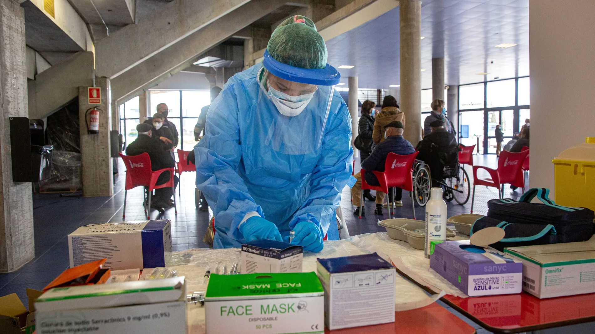 Una sanitaria prepara la dosis para vacunar contra la Covid en el vestíbulo del Palacio de los Deportes de Logroño