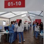 Varios sanitarios en el momento de suspenderse la vacunación con viales de AstraZeneca de miles de docentes de la Comunidad Valenciana en el hospital de campaña de La Fe, de Valencia.