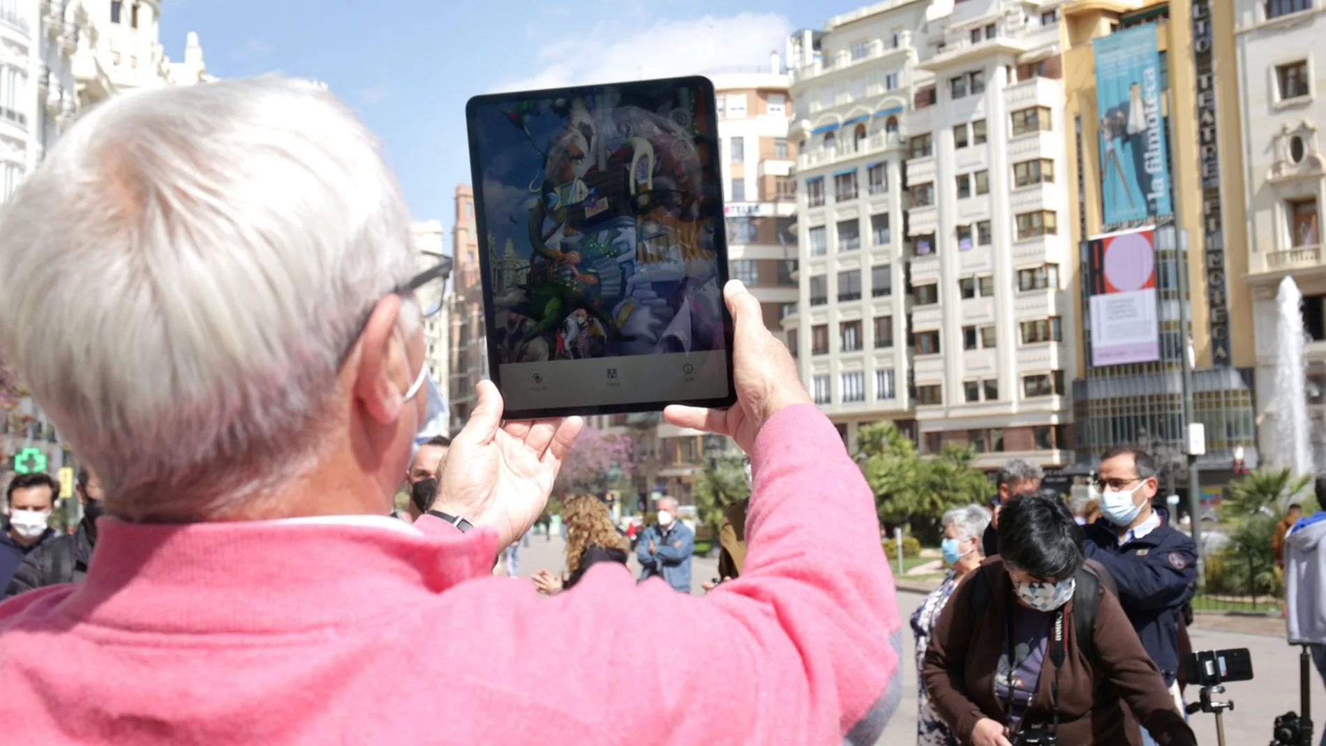 El alcalde de Valencia, Joan Ribó, contempla la falla que se hubiera plantado en la plaza del Ayuntamiento y que la pandemia ha impedido. Una app de realidad aumentada permite contemplar el monumento.