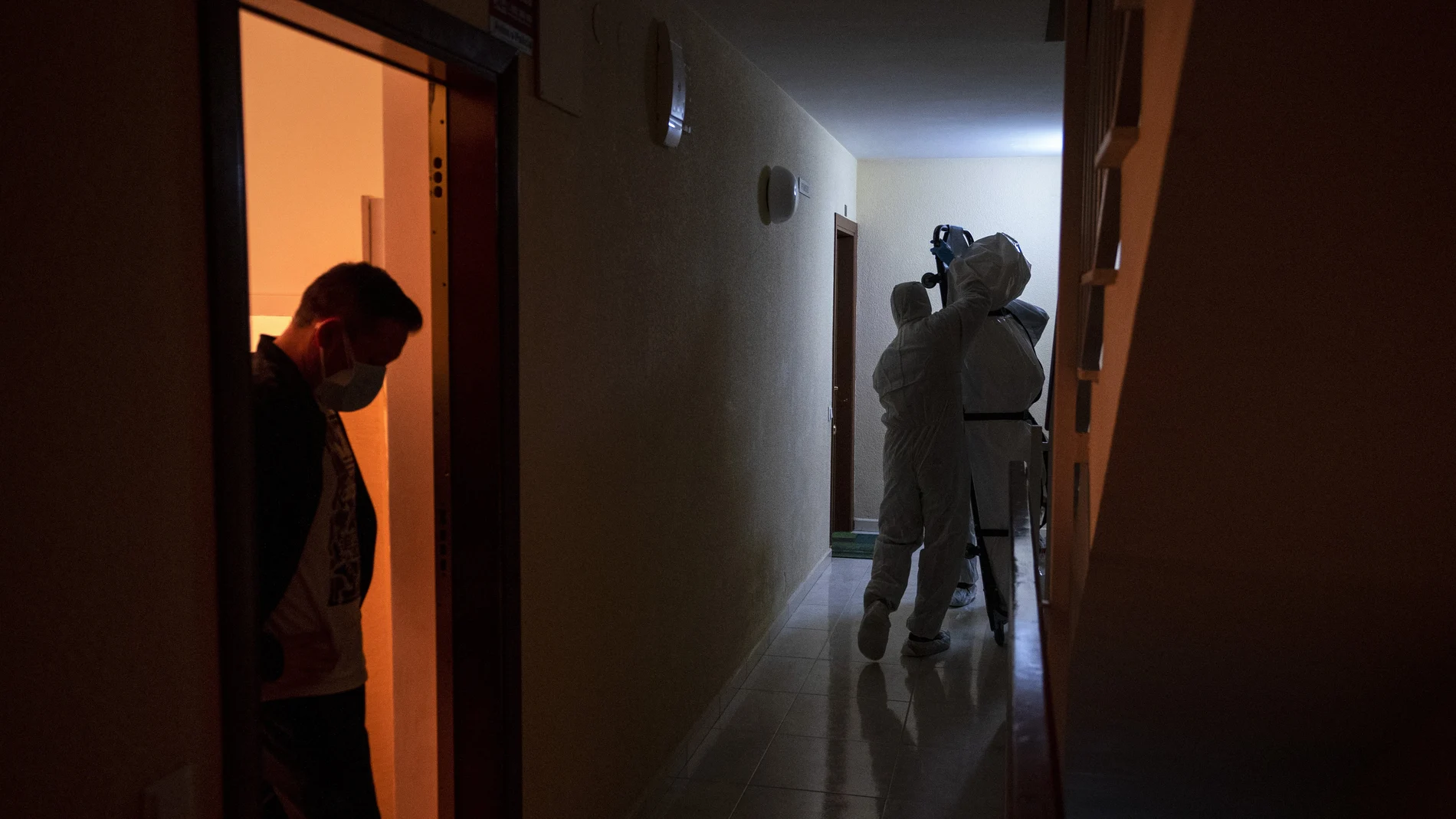 Trabajadores de un tanatorio trasladan el cadáver de un anciano fallecido por Covid-19 en el interior de su domicilio en Barcelona