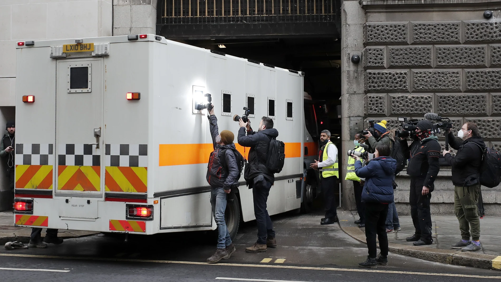 Journalists try to take pictures of the inside of a prison van moving into the Old Bailey, the Central Criminal Court in London, Tuesday, March 16, 2021. Serving British police officer Wayne Couzens stands accused of the kidnap and murder of 33-year-old Sarah Everard, who went missing while walking home in south London on March 3. (AP Photo/Frank Augstein)