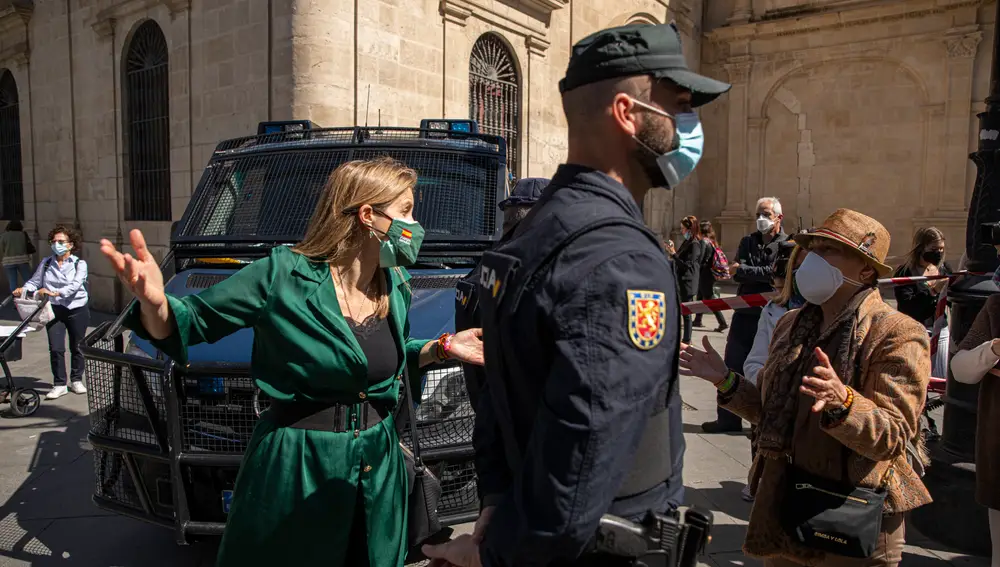 La concejal de Vox en el Ayto. de Sevilla, Cristina Pelaez (i), conversa con una mujer que reclama acceder a la rueda de prensa del presidente de Vox, Santiago Abascal, en la Plaza Nueva