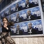 Niños israelíes caminan frente al cartel electoral del líder del Likud, Benjamín Netanyahu