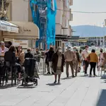Varias personas pasean por una céntrica calle de Sanxenxo, Pontevedra, Galicia (España)