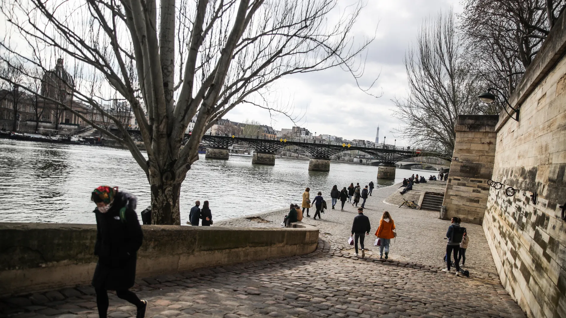 Varias personas junto al río Sena con la Torre Eiffel de fondo, en París, este finde de semana