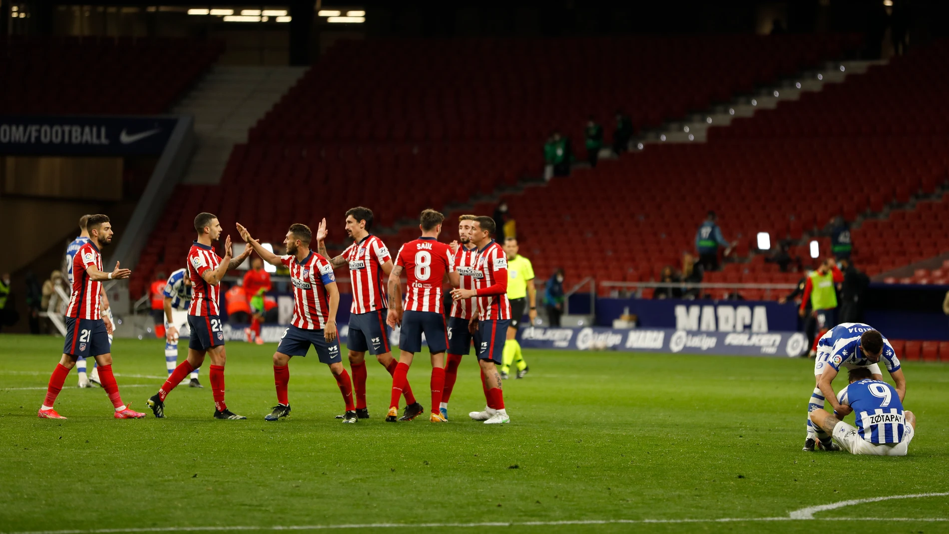 Los jugadores del Atlético celebran el triunfo mientras Rioja intenta consolar a Joselu