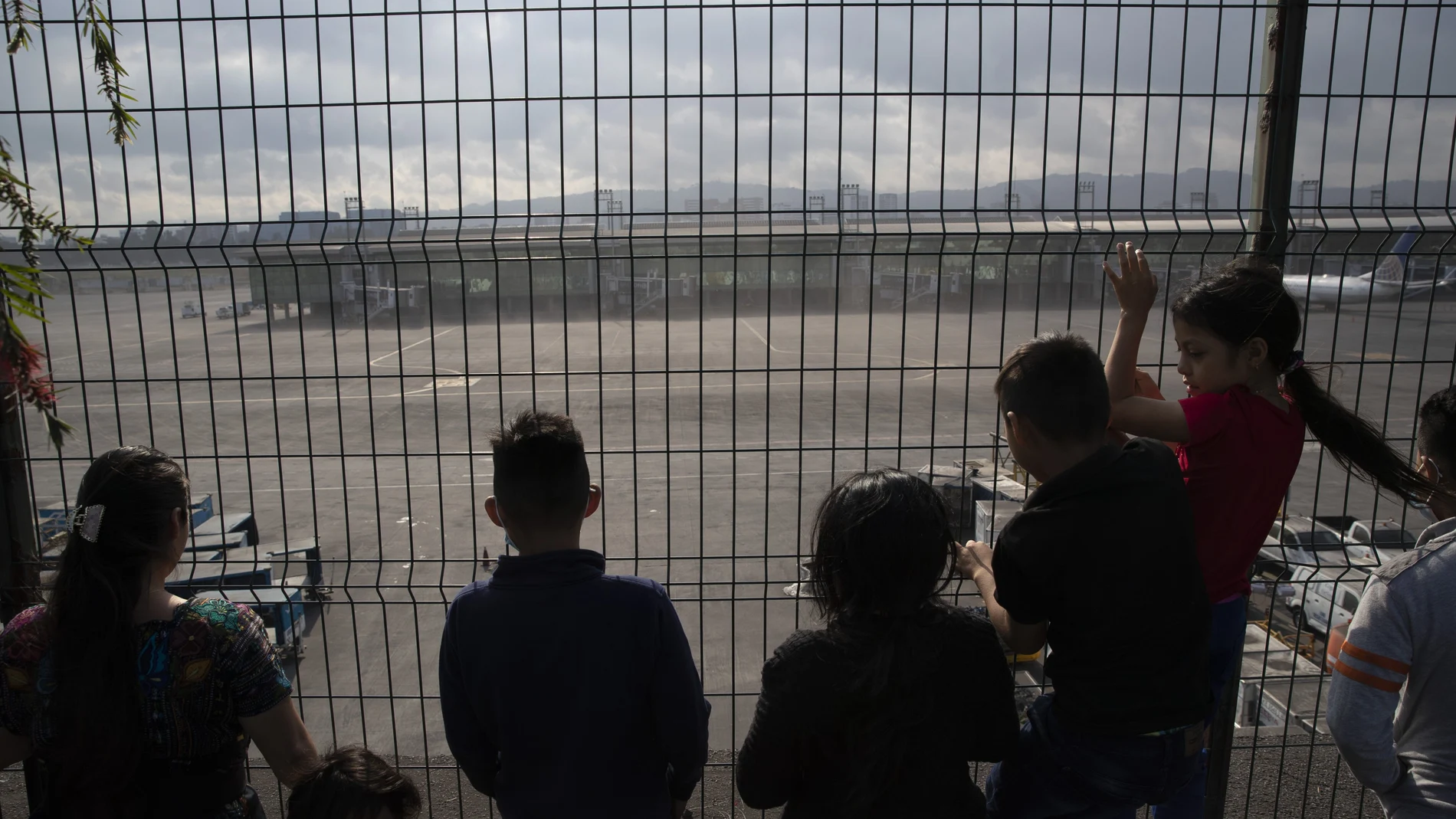 People look at planes parked at the La Aurora international airport which has been closed due to an eruption at the Pacaya volcano in Guatemala City, Tuesday, March 23, 2021. (AP Photo/Moises Castillo