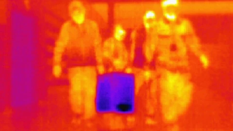 Imagen tomada con una cámara térmica que muestra a un equipo especial trasladando vacunas Pfizer en una caja con criogénica, este miércoles en el sur de Seúl. EFE/ Yonhap