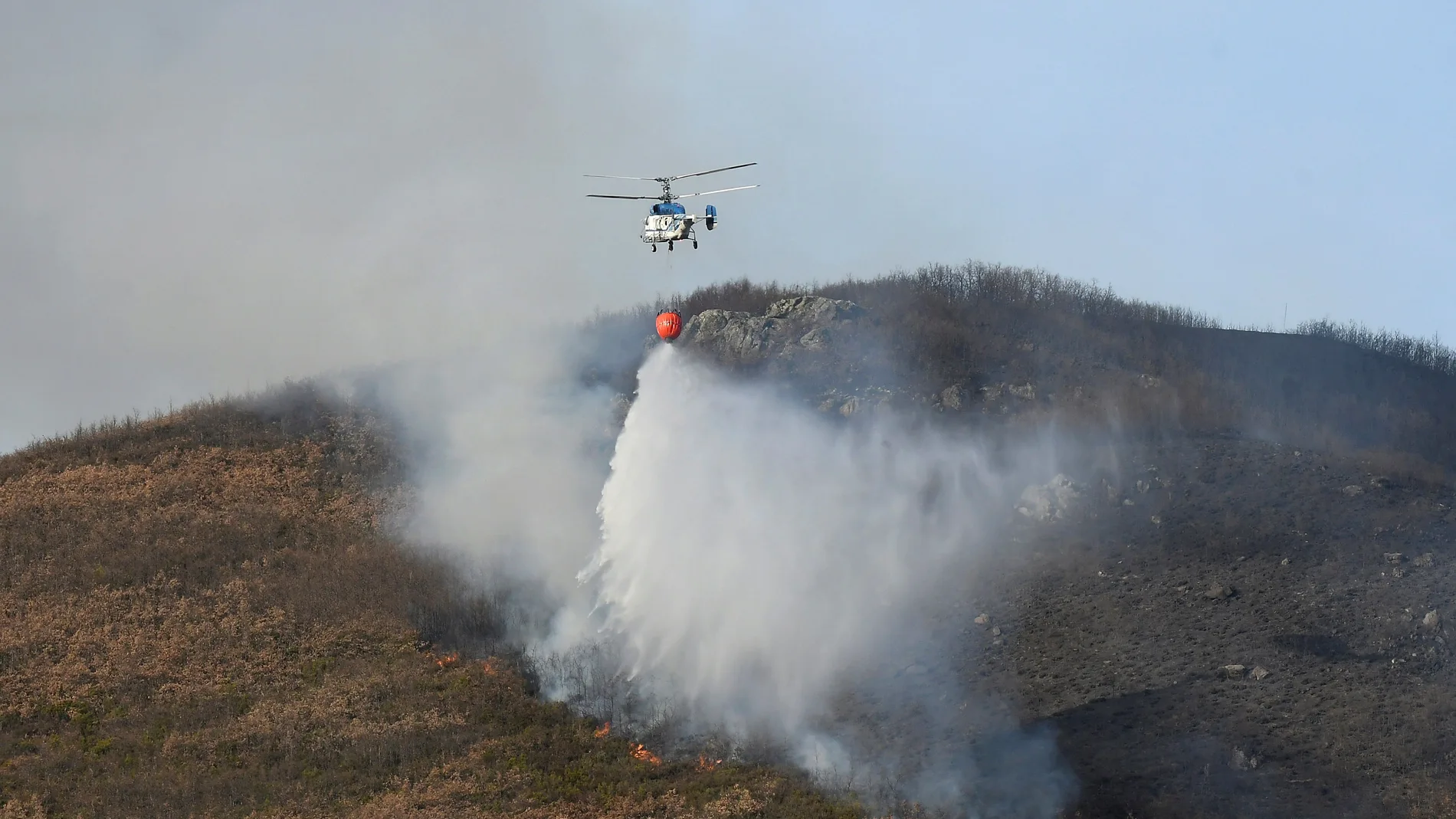 Medios aéreos durante la extinción del incendio que afecta a un robledal en la localidad de Renedo de Curueño (León)