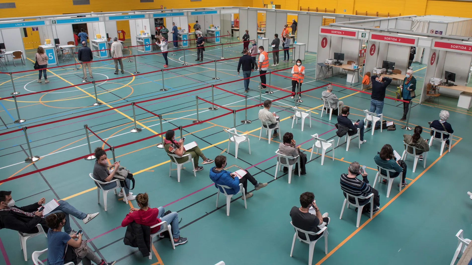 Varias personas son vacunadas contra la covid-19 en el Polideportivo Germans Escalas de Palma de Mallorca tras haberse retomado este miércoles la vacunación con dosis de la farmacéutica AstraZeneca