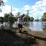 A man cleans up debris in front of his house in the suburb of Windsor as the state of New South Wales experiences widespread flooding and severe weather, near Sydney, Australia, March 24, 2021. REUTERS/Jaimi Joy
