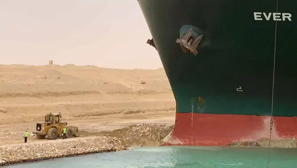 Una excavadora trabaja en las tareas para desencallar el Ever Given en Suez