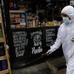 24 March 2021, Venezuela, Sucre: A Sucre city government worker sprays a solution of hypochlorite and water to prevent Coronavirus (Covid-19) infection in a store selling food, detergents and lubricants for vehicles. Photo: Jesus Vargas/dpa24/03/2021 ONLY FOR USE IN SPAIN
