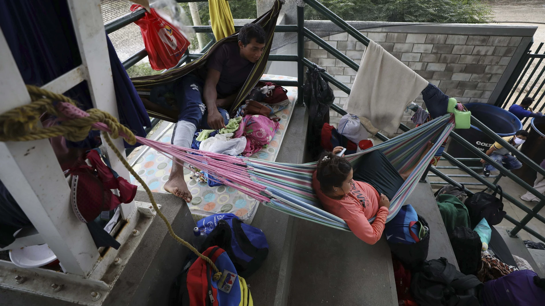 Venezuelans rest at a community center being used as a shelter in Arauquita, Colombia, Thursday, March 25, 2021, on the border with Venezuela. Thousands of Venezuelans are seeking shelter in Colombia this week following clashes between Venezuela's military and a Colombian armed group in a community along the nations' shared border. (AP Photo/Fernando Vergara)