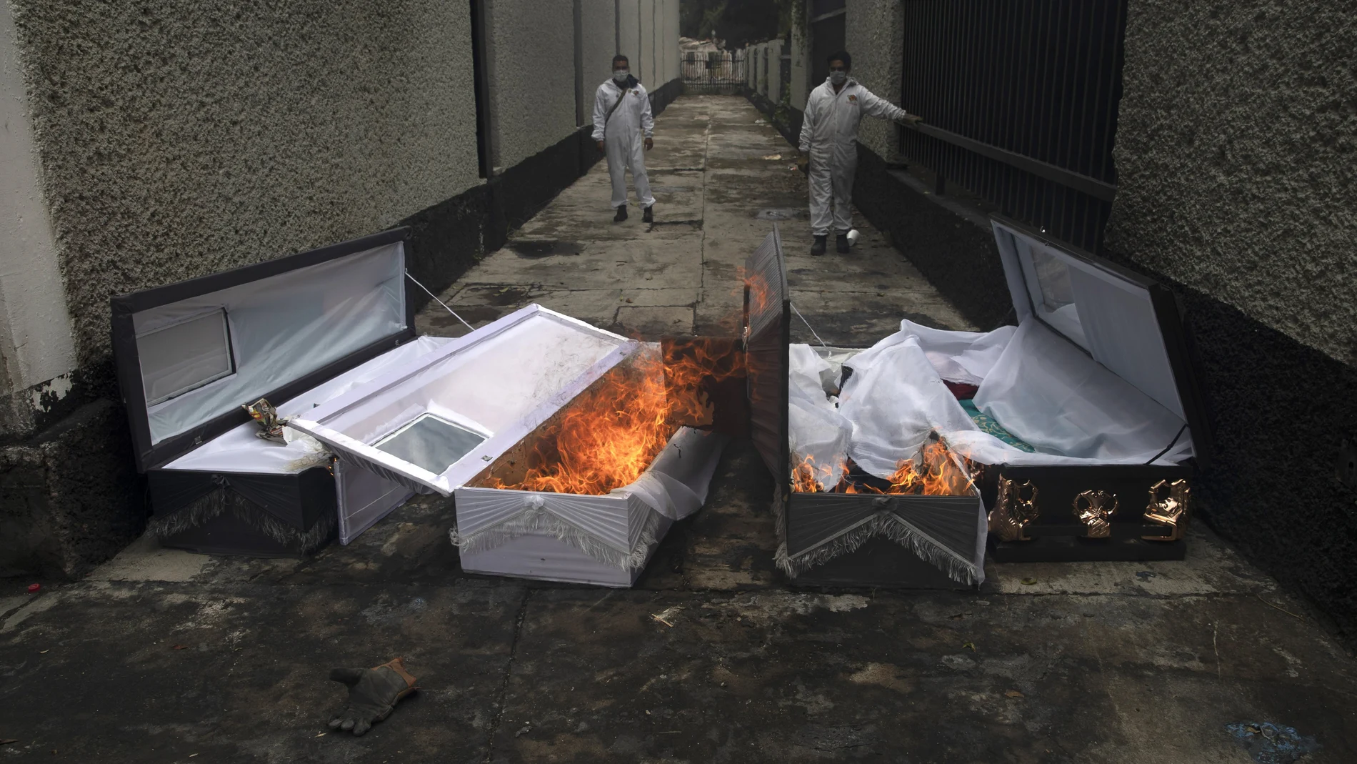 FILE - In this June 24, 2020 file photo, crematorium workers burn the coffins that contained the remains of people who died from the coronavirus after their cremation at the San Nicolas Tolentino cemetery in the Iztapalapa neighborhood of Mexico City. As Mexico approaches 200,000 in officially test-confirmed deaths from COVID-19, the real death toll is probably higher due to the countryâ€™s extremely low rate of testing. (AP Photo/Marco Ugarte, File)