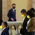 El candidato de ERC, Pere Aragonés, junto a varios diputados de JxCat, en los pasillos del Parlament.