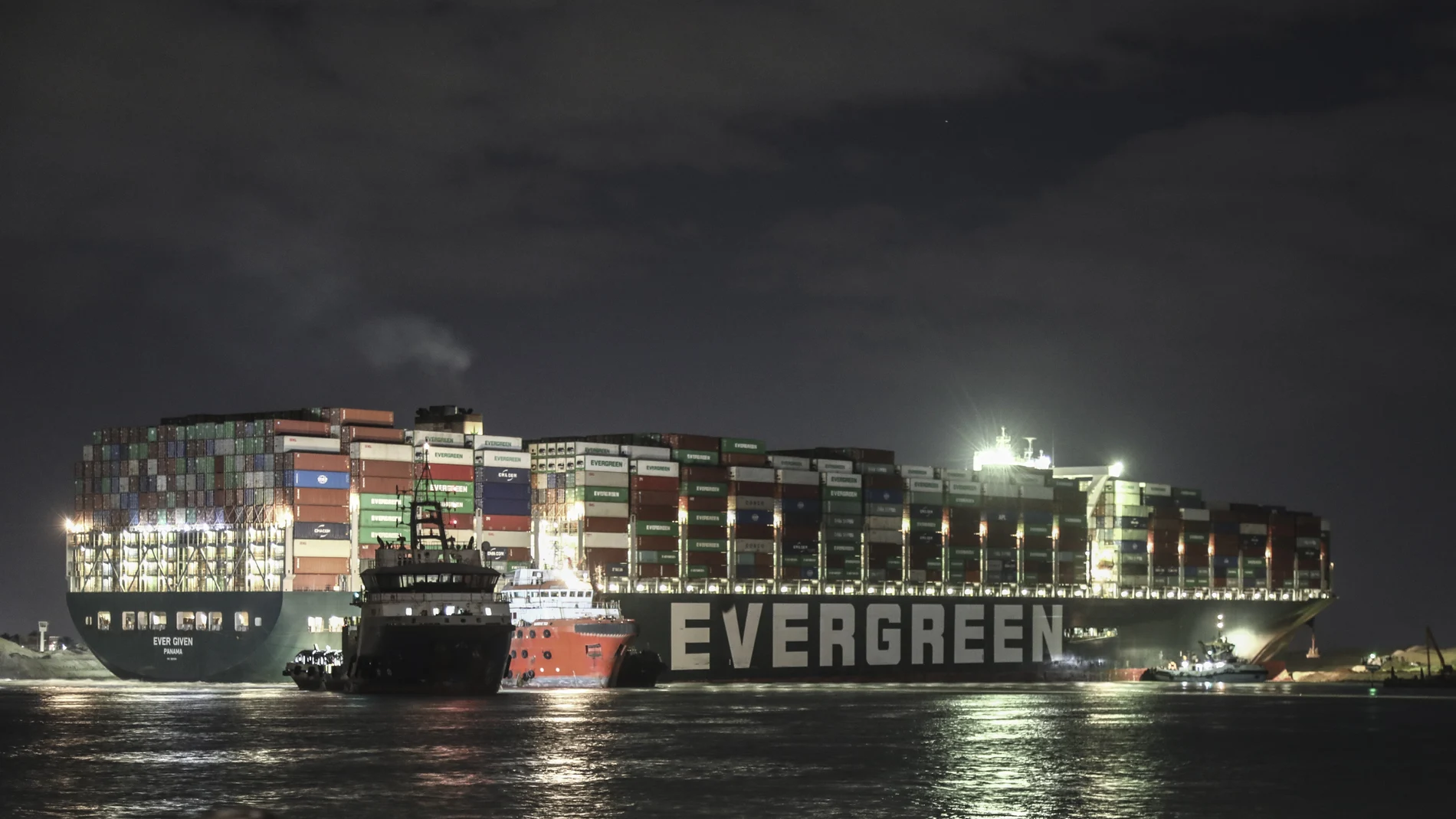 El carguero "Ever Given", iluminado mientras los remolcadores intentan reflotarlo por la noche