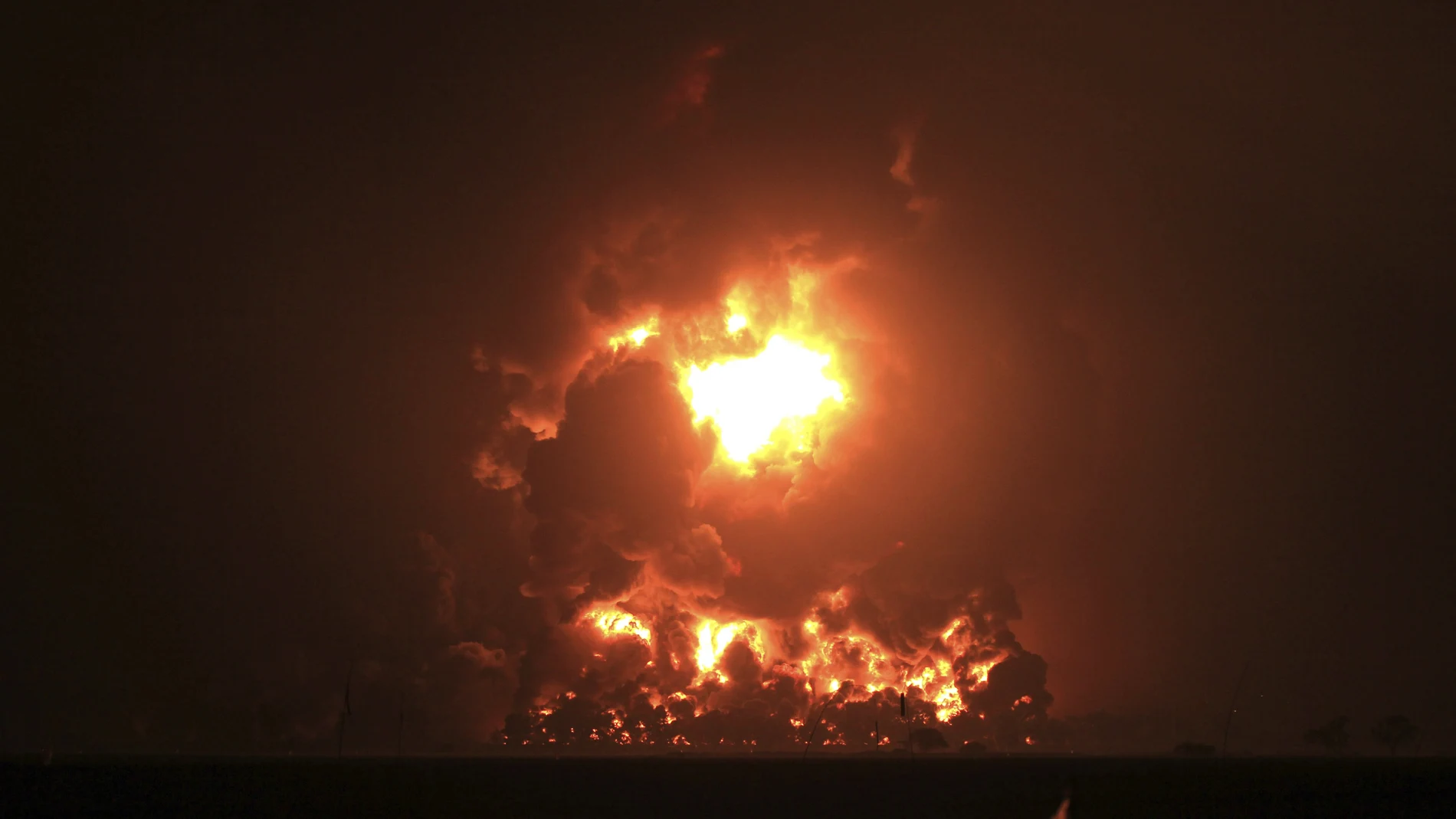 Night sky glows from a fire that razes through Pertamina Balongan Refinery in Indramayu, West Java, Indonesia, early Monday, March 29, 2021. Hundreds of people were evacuated from a nearby village after the massive fire broke out at the refinery. (AP Photo)